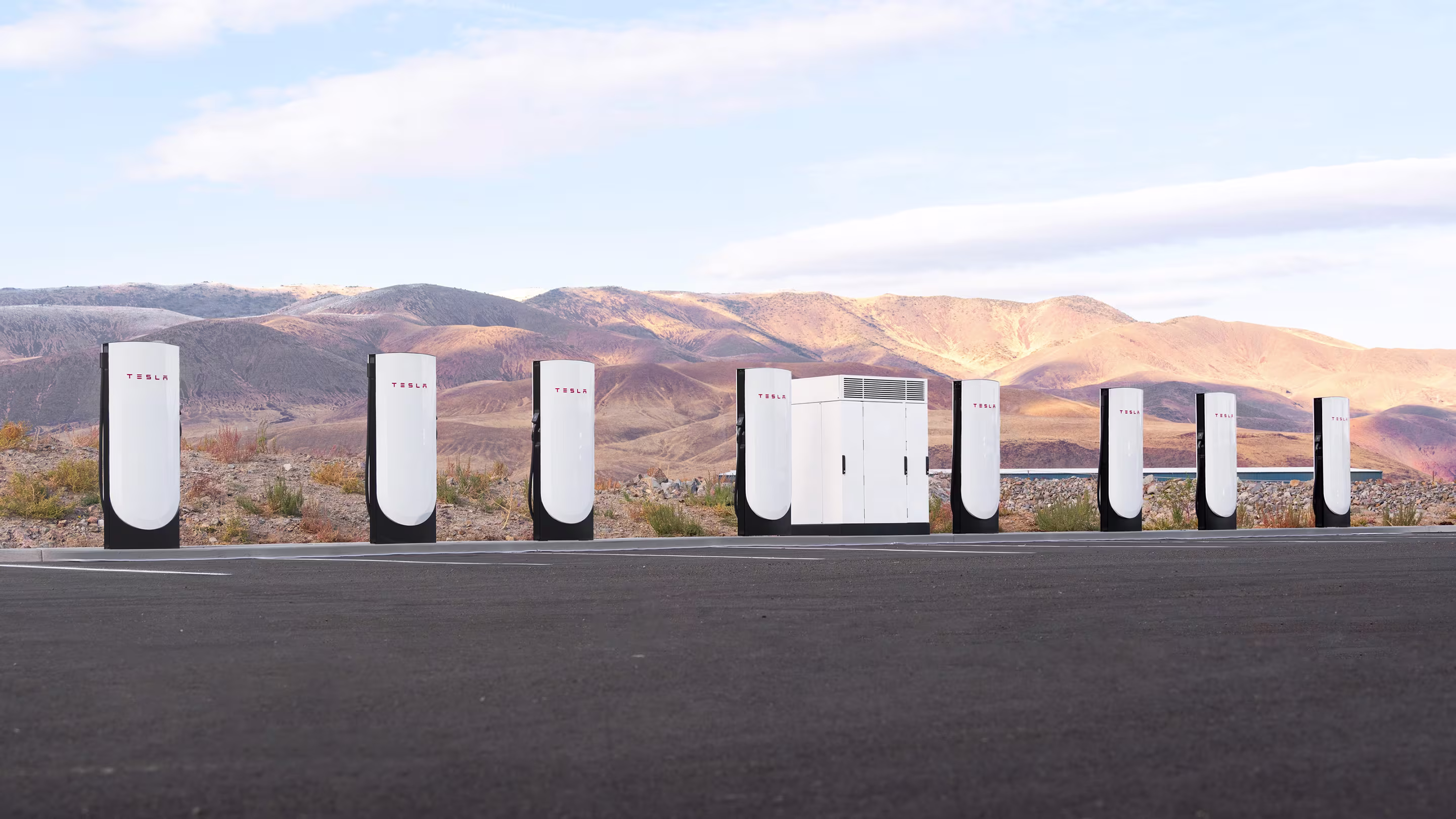 Dağ manzarası önünde Supercharger istasyonu tam genişlik görseli