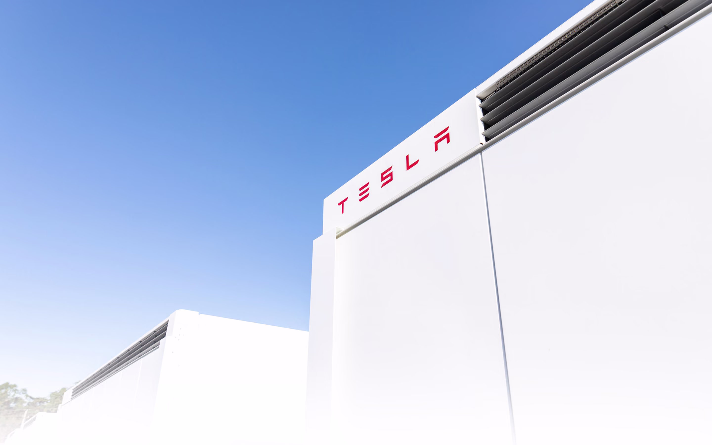 Megapack modülleri ve Tesla logosu, geniş gökyüzü